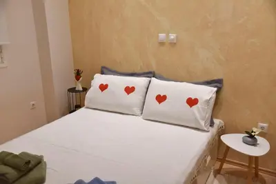 a bedroom with two pillows with hearts on them at Tiny Treasure Apartment in Athens