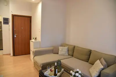 a living room with a couch and a table at Tiny Treasure Apartment in Athens