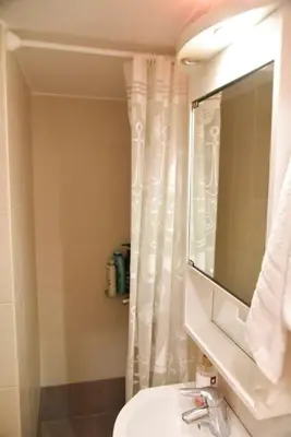 a bathroom with a white shower curtain and a sink at Tiny Treasure Apartment in Athens