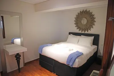 a bedroom with a bed with a mirror on the wall at Sunset Sea Mini Studio Anavissos in Anavissos