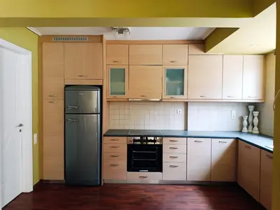 a kitchen with wooden cabinets and a black refrigerator at Sunset Sea Mini Studio Anavissos in Anavissos