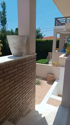 a vase sitting on a brick wall on a patio at Sunset Sea Mini Studio Anavissos in Anavissos