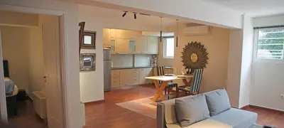 a living room and kitchen with a couch and a table at Sunset Sea Mini Studio Anavissos in Anavissos
