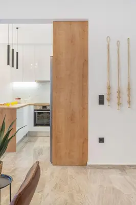 a kitchen with white cabinets and a wooden door at LIV - Modern Flat in Kolonaki in Athens