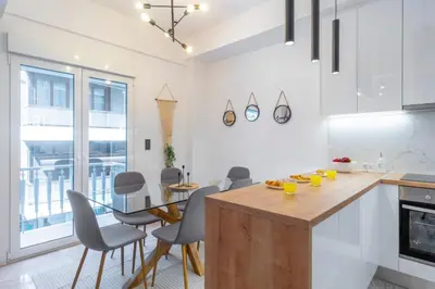 a kitchen with a table and chairs and a dining room at LIV - Modern Flat in Kolonaki in Athens