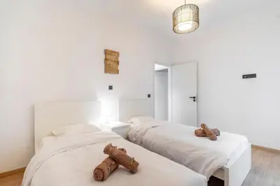 two beds in a room with white walls at LIV - Modern Flat in Kolonaki in Athens