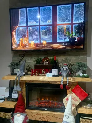 a fireplace in front of a window with christmas lights at Zoe garden home in Spáta