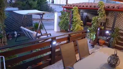 a balcony with a table and chairs and an umbrella at Zoe garden home in Spáta
