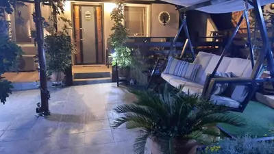 a porch with couches and a palm tree at Zoe garden home in Spáta