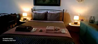 a bedroom with a bed with towels and shoes on it at Zoe garden home in Spáta