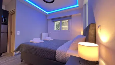 a bedroom with a bed with a blue light on it at FlatG 23 in Athens