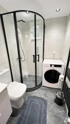 a bathroom with a shower and a toilet and a microwave at FlatG 23 in Athens