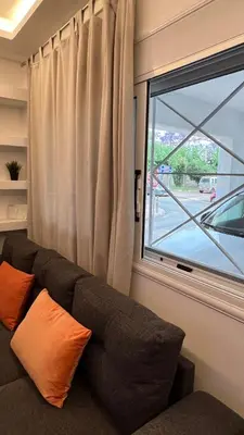 a couch sitting in a room with a window at FlatG 23 in Athens
