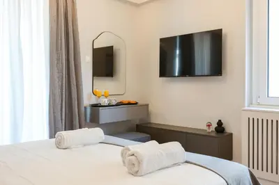 a bedroom with two beds and a television on the wall at Prime location Athens Exec 2BD Apt by Live&Travel in Athens
