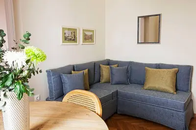 a blue couch in a living room with a table at Pagrati Hilton location Bentzi Family Suite 5 in Athens