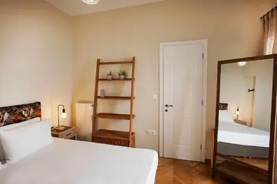 a bedroom with a bed and a mirror and a ladder at Pagrati Hilton location Bentzi Family Suite 5 in Athens
