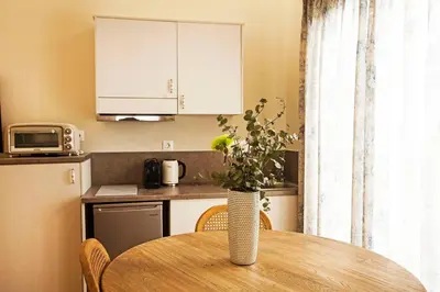 a kitchen with a table with a vase of flowers on it at Pagrati Hilton location Bentzi Family Suite 5 in Athens