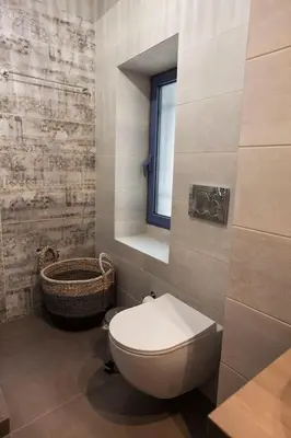 a bathroom with a toilet and a window at Pagrati Hilton location Bentzi Family Suite 5 in Athens
