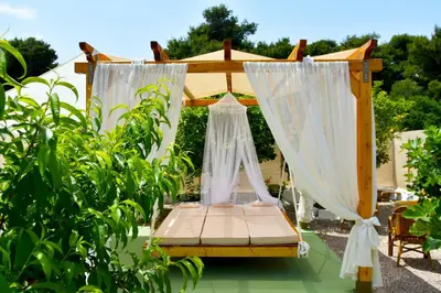 a bed with a canopy and curtains in a garden at Camping Tent Downtown & Garden Hanging Bed in Porto Rafti