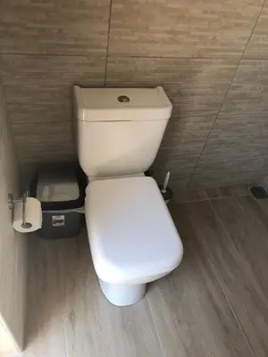 a white toilet in a bathroom with a trash can at Camping Tent Downtown & Garden Hanging Bed in Porto Rafti