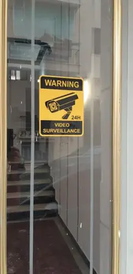 a sign on the window of a door with awarning sign at Luxury apartment 3 rooms near metro in Athens