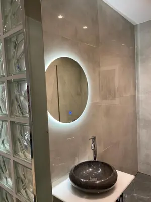 a bathroom with a sink and a circular mirror at Marina Access in Athens