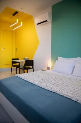 a bedroom with a bed and a table with chairs at G&H Acropolis Stays! Iconic Views, Stylish Comfort in Athens