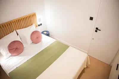 a bedroom with a bed with two pink pillows at G&H Acropolis Stays! Iconic Views, Stylish Comfort in Athens