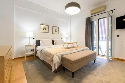 a bedroom with a bed with a table and a window at Modern Two-Bedroom Apartment In Kolonaki, Peridot - Homes in Athens