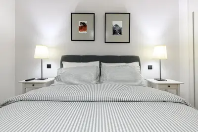 a white bedroom with a large bed with two lamps at Modern Two-Bedroom Apartment In Kolonaki, Peridot - Homes in Athens