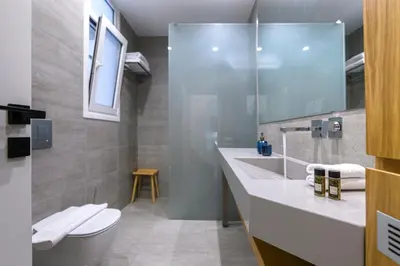 a bathroom with a sink and a toilet and a mirror at Modern Two-Bedroom Apartment In Kolonaki, Peridot - Homes in Athens