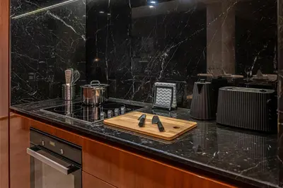 a kitchen counter with a cutting board and a knife at Modern Two-Bedroom Apartment In Kolonaki, Peridot - Homes in Athens