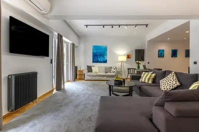 a living room with a couch and a flat screen tv at Modern Two-Bedroom Apartment In Kolonaki, Peridot - Homes in Athens