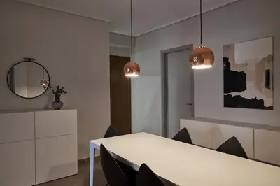 a dining room with a white table and chairs at Chic designer home next - Hilton in Athens