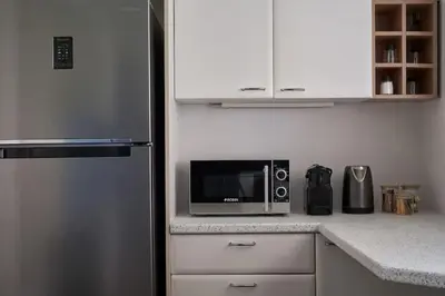 a kitchen with a microwave and a refrigerator at Chic designer home next - Hilton in Athens
