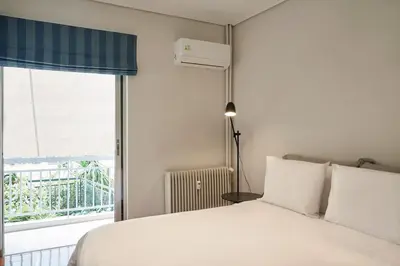 a bedroom with a white bed and a window at Chic designer home next - Hilton in Athens