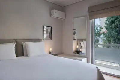 a white bedroom with a large bed and a window at Chic designer home next - Hilton in Athens