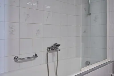a bathroom with a shower with a glass door at Chic designer home next - Hilton in Athens