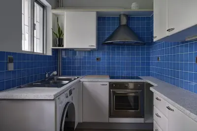 a blue tiled kitchen with a sink and a dishwasher at Chic designer home next - Hilton in Athens