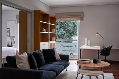 a living room with a couch and a table at Chic designer home next - Hilton in Athens