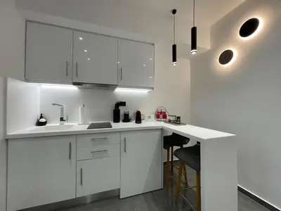 a white kitchen with white cabinets and bar stools at Monastiraki 512 SuperHost Hub in Athens