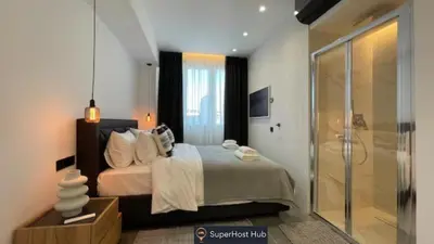 a bedroom with a bed and a glass shower at Monastiraki 512 SuperHost Hub in Athens