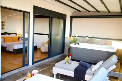 a living room with a tub and a bedroom at Alex Suite Θερμαινόμενο Τζακούζι & Θέα Ακρόπολη in Athens