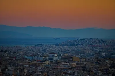 a view of a city at sunset at Alex Suite Θερμαινόμενο Τζακούζι & Θέα Ακρόπολη in Athens
