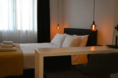 a bedroom with a bed with white pillows and a table at Monastiraki 513 SuperHost Hub in Athens