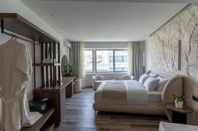 a bedroom with a bed and a large window at Athens Design Suites in Athens