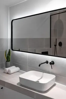 a bathroom with a white sink and a large mirror at Athens Design Suites in Athens