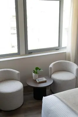 a hotel room with two chairs and a table and windows at Athens Design Suites in Athens