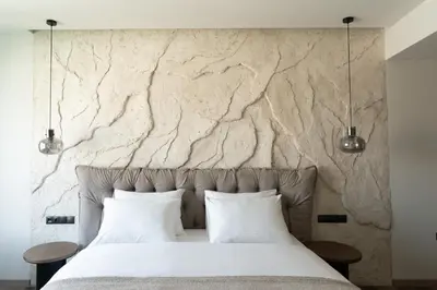a bedroom with a stone wall and a bed with two pillows at Athens Design Suites in Athens