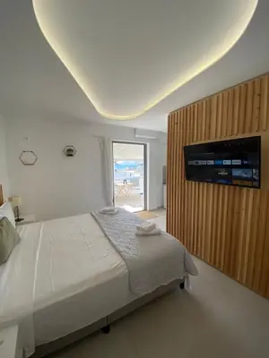 a bedroom with a bed and a television on a wall at Serafina suite byArtistUnknown in Vari